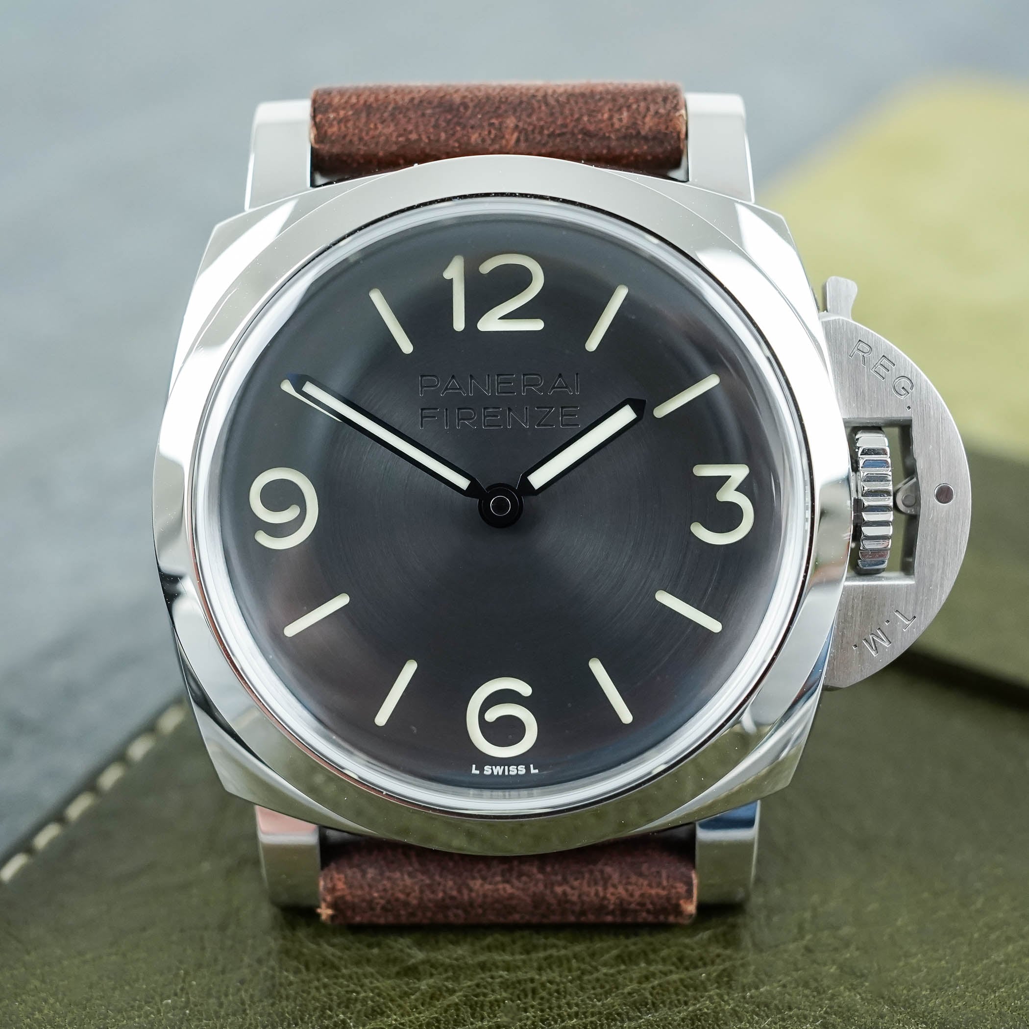 The steel PAM01794 seen straight on, a black circular-brushed sandwich dial reading Panerai Firenze with green Super-LumiNova numerals and blue-finished pencil hands, in a polished Luminor cushion case