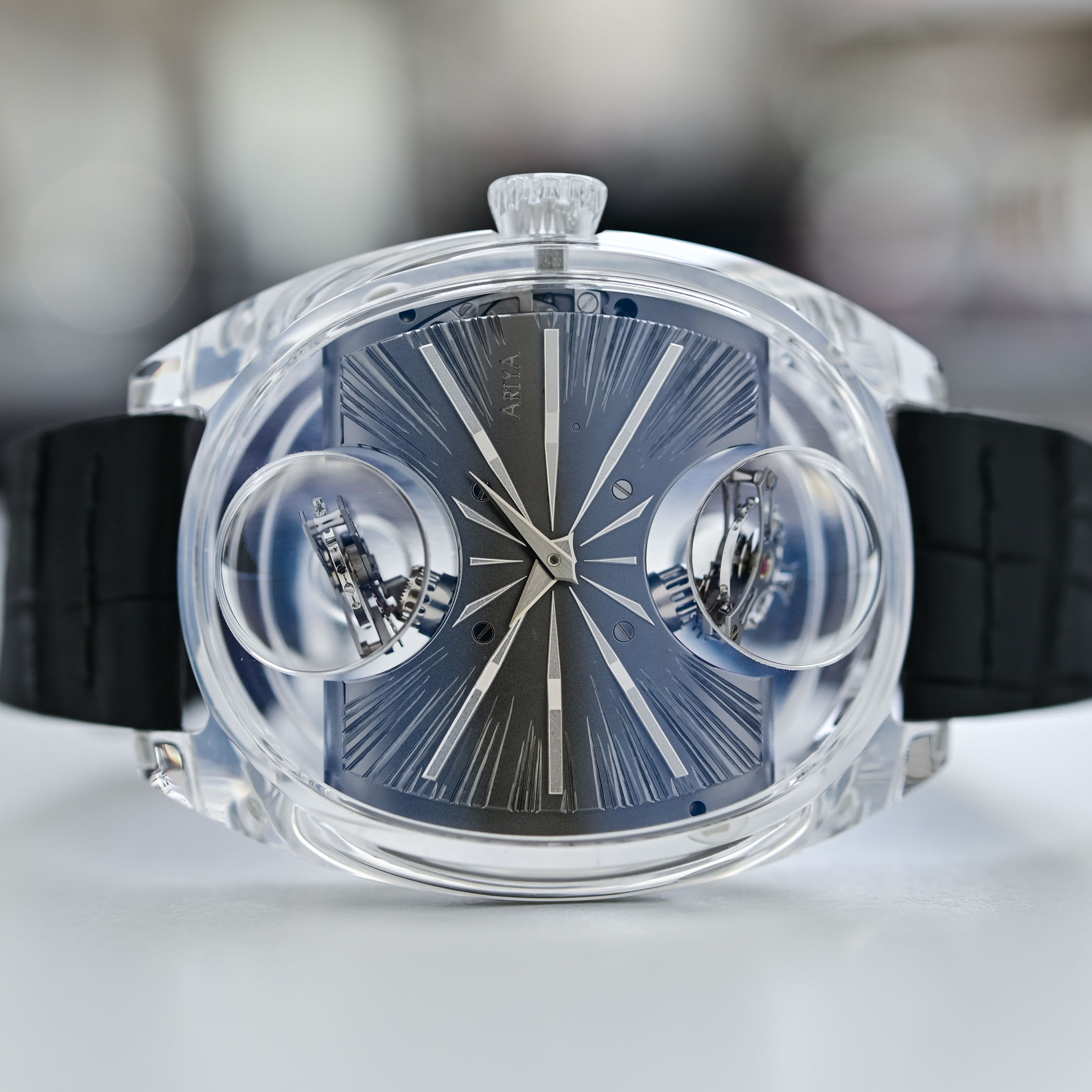 The transparent sapphire case seen from the front, the two tourbillon domes bulging from the case flanks and the faceted crown also cut from crystal