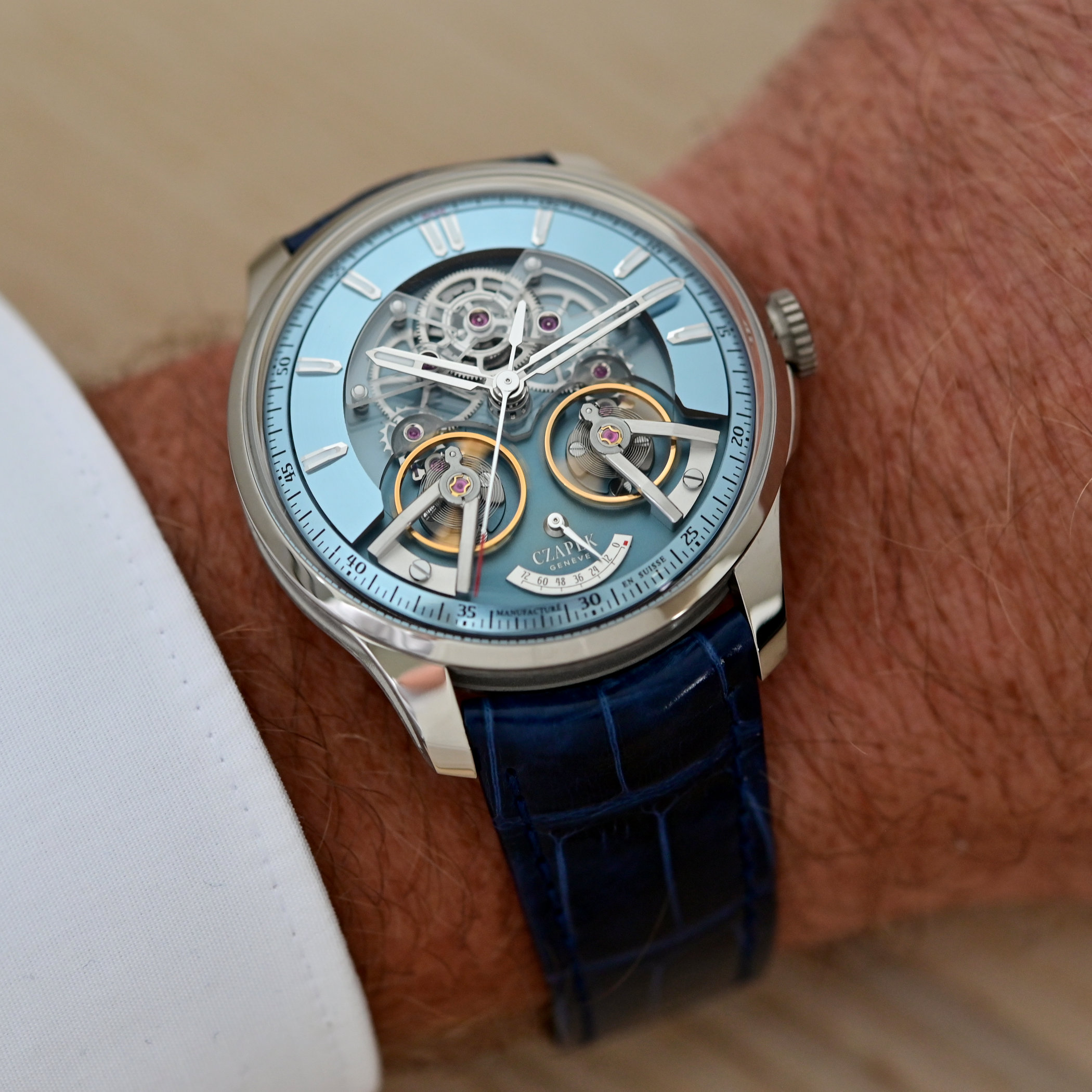 The Czapek Place Vendôme Complicité Glacier Blue on the wrist, its platinum case and glacier-blue chapter ring framing the openworked movement, two balance wheels with gold rings and a power reserve scale, on a blue alligator strap